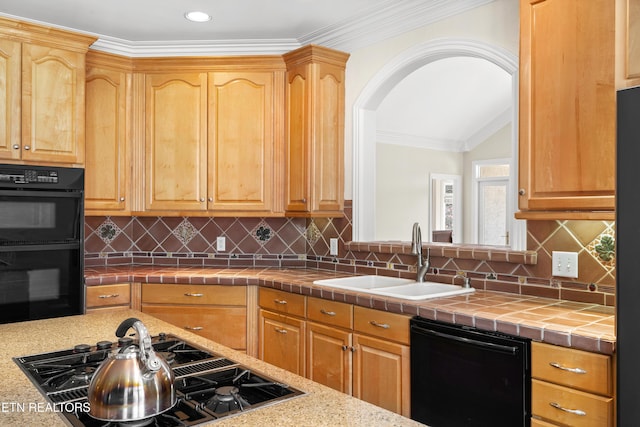 kitchen with arched walkways, tile counters, tasteful backsplash, a sink, and black appliances