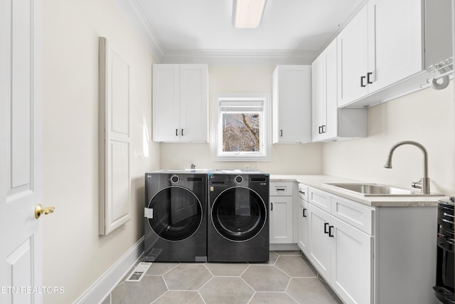 laundry room with light tile patterned floors, a sink, independent washer and dryer, cabinet space, and crown molding