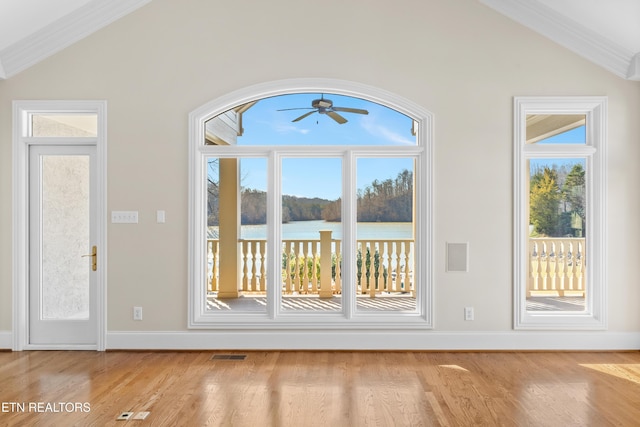 doorway featuring visible vents, vaulted ceiling, light wood finished floors, and a water view