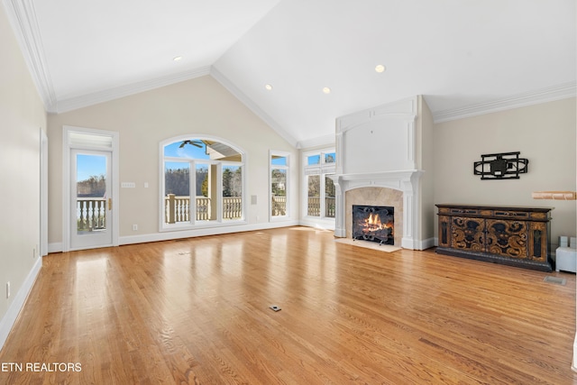 unfurnished living room with baseboards, ornamental molding, a fireplace with flush hearth, and light wood-style floors