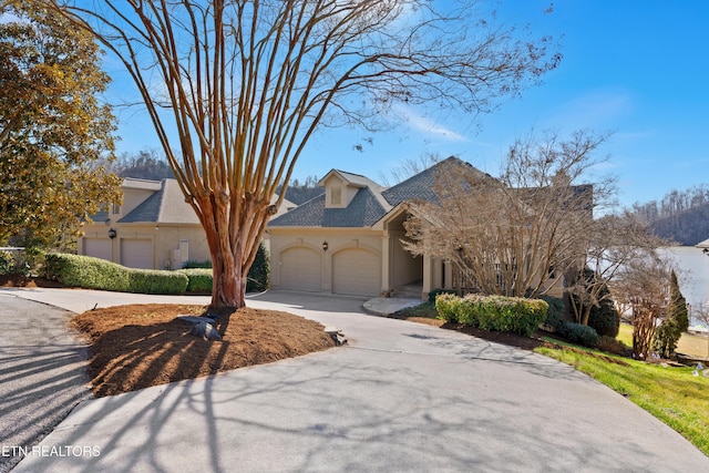 view of front of house with a garage, concrete driveway, and stucco siding