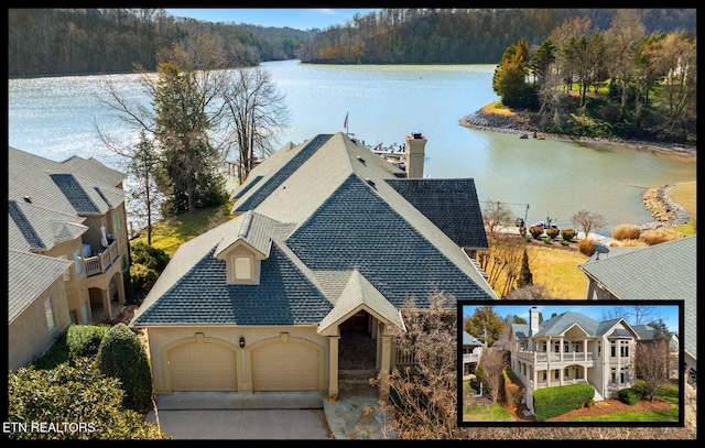 view of front of property featuring a water view, driveway, an attached garage, and roof with shingles