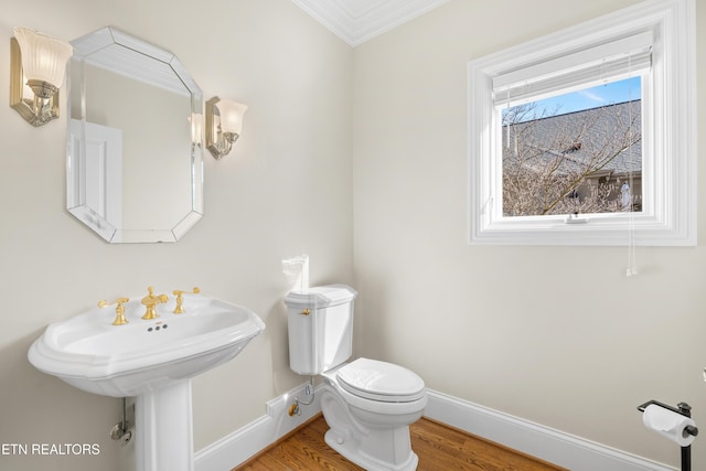 bathroom with toilet, baseboards, and wood finished floors