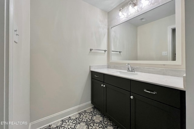 bathroom with visible vents, vanity, baseboards, and tile patterned floors