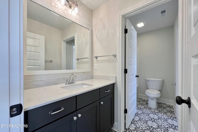 bathroom featuring baseboards, visible vents, toilet, tile patterned flooring, and vanity