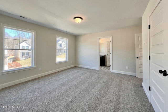 unfurnished bedroom with carpet, visible vents, baseboards, and ensuite bathroom