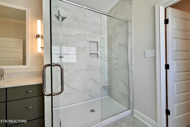 full bath featuring crown molding, a shower stall, baseboards, and vanity