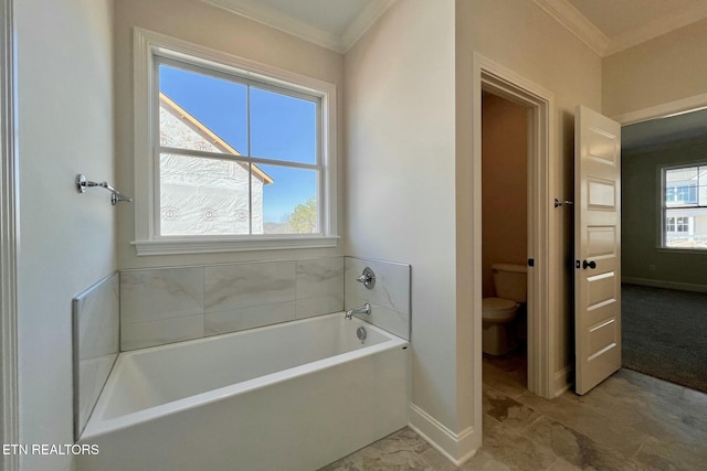 bathroom with baseboards, a garden tub, crown molding, and toilet