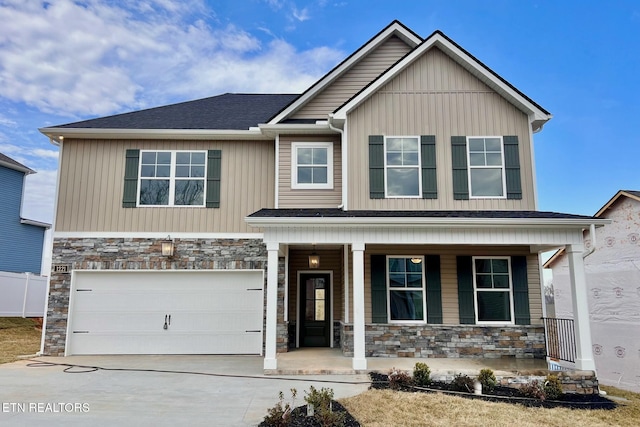 craftsman inspired home featuring a garage, concrete driveway, stone siding, a porch, and board and batten siding