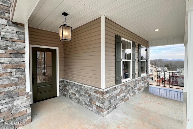 property entrance featuring stone siding, a porch, and brick siding