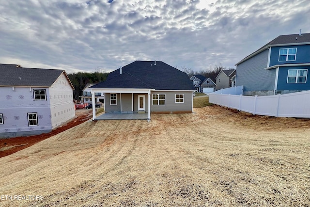 rear view of house featuring a patio area and fence