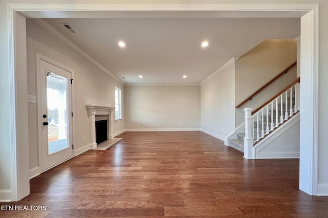 unfurnished living room with baseboards, stairway, ornamental molding, wood finished floors, and a fireplace