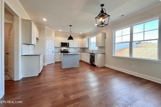 kitchen with stainless steel appliances, ornamental molding, dark wood finished floors, and visible vents