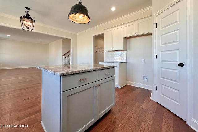 kitchen with dark wood-style floors, pendant lighting, crown molding, and tasteful backsplash