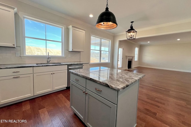 kitchen with crown molding, dark wood finished floors, backsplash, stainless steel dishwasher, and a sink