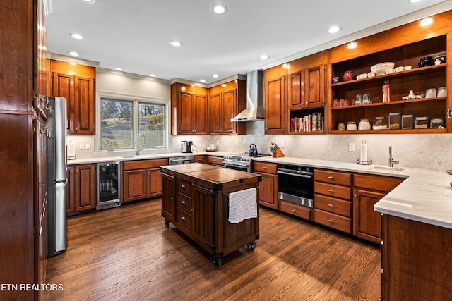 kitchen with beverage cooler, a sink, dark wood finished floors, appliances with stainless steel finishes, and wall chimney range hood