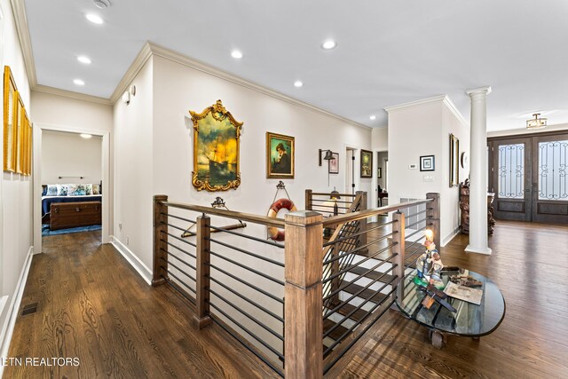 corridor with decorative columns, an upstairs landing, baseboards, and wood finished floors