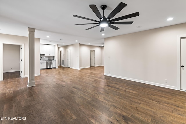 unfurnished living room featuring a ceiling fan, dark wood-style floors, recessed lighting, and ornate columns