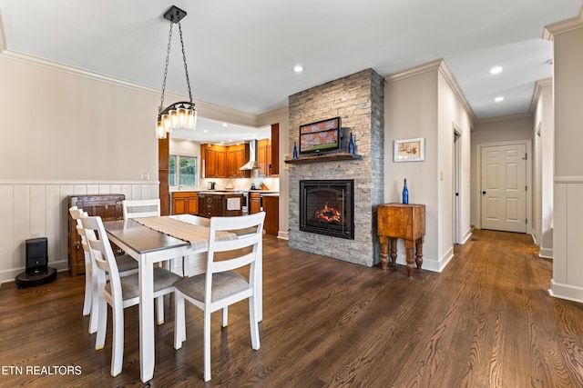 dining space with a stone fireplace, crown molding, recessed lighting, and dark wood finished floors