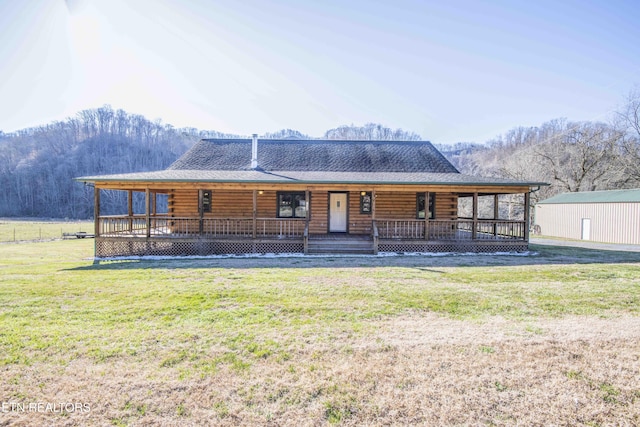 log home featuring a porch, log siding, a front lawn, and roof with shingles