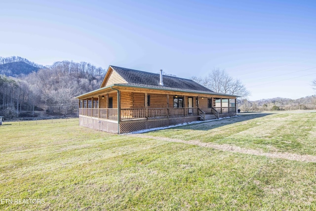 view of front of home with a front yard, covered porch, and log exterior