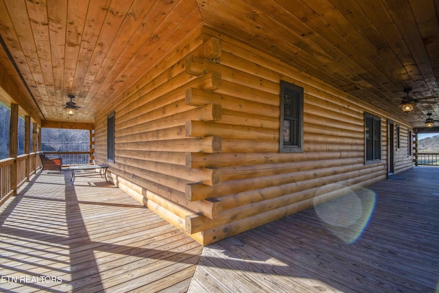 wooden terrace featuring covered porch and a ceiling fan