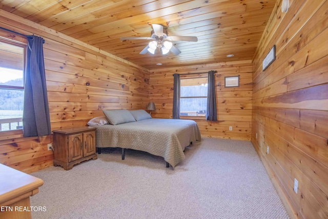 bedroom featuring wood ceiling, light colored carpet, and wooden walls