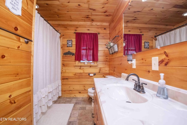 bathroom with wood walls, wood ceiling, stone finish flooring, and vanity