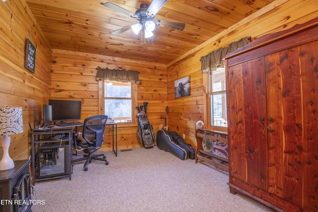 carpeted home office featuring a ceiling fan, wooden ceiling, and wood walls