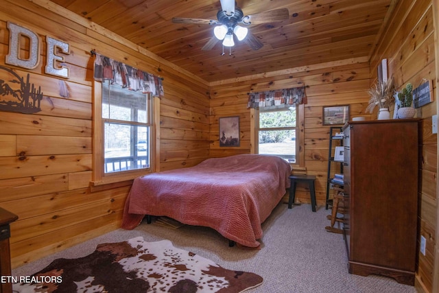 bedroom featuring wood walls, wood ceiling, and carpet flooring