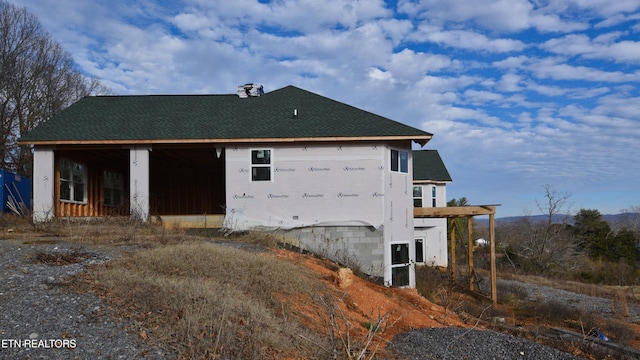 view of home's exterior with roof with shingles