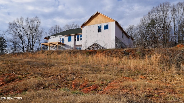 rear view of house featuring stucco siding