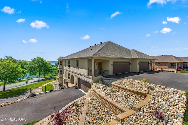 view of front facade featuring aphalt driveway, roof with shingles, fence, and stucco siding