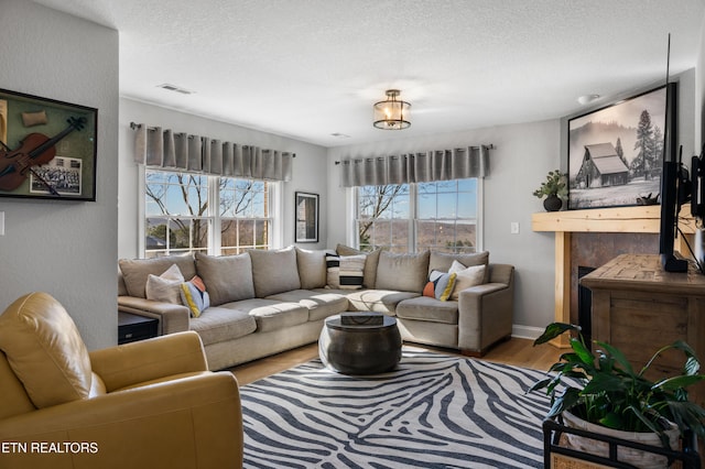 living room featuring visible vents, a textured ceiling, and wood finished floors