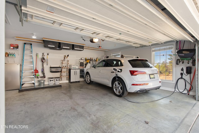 garage featuring a garage door opener and freestanding refrigerator