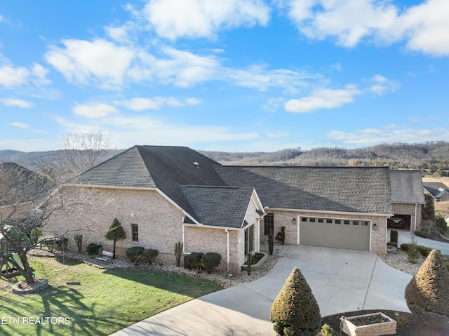 view of front facade featuring brick siding, a shingled roof, a front yard, a garage, and driveway