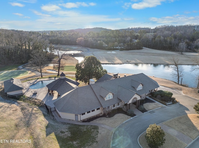 drone / aerial view with a forest view and a water view