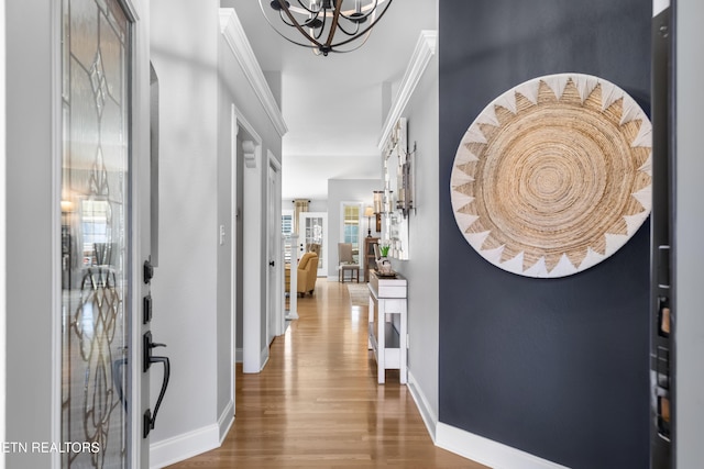 entryway with wood finished floors, baseboards, and a chandelier