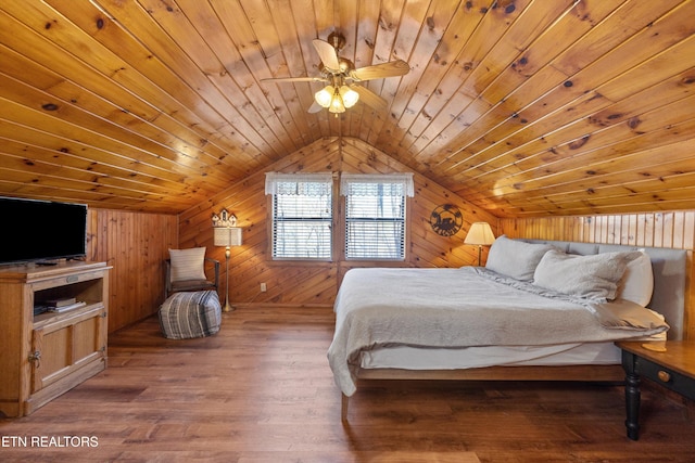 bedroom with lofted ceiling, ceiling fan, wooden ceiling, wooden walls, and wood finished floors