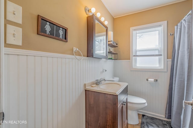full bath featuring vanity, toilet, and wainscoting