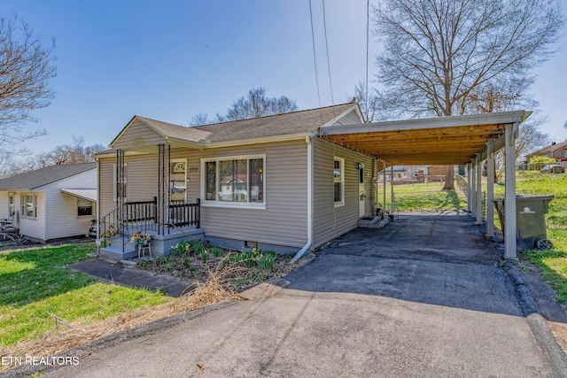 view of front of house with an attached carport, a front yard, driveway, and crawl space