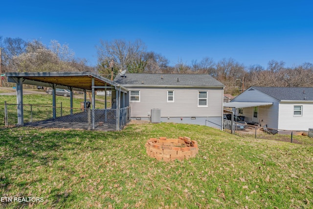 back of property with crawl space, a fenced backyard, a fire pit, and a yard