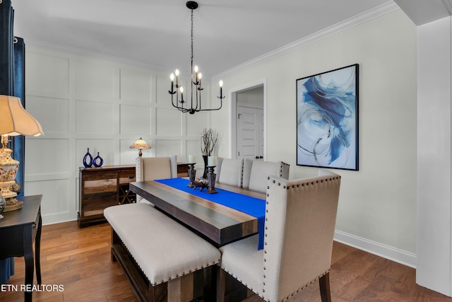 dining room featuring a decorative wall, crown molding, and wood finished floors