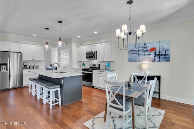 kitchen with stainless steel appliances, white cabinetry, dark wood-style floors, and tasteful backsplash