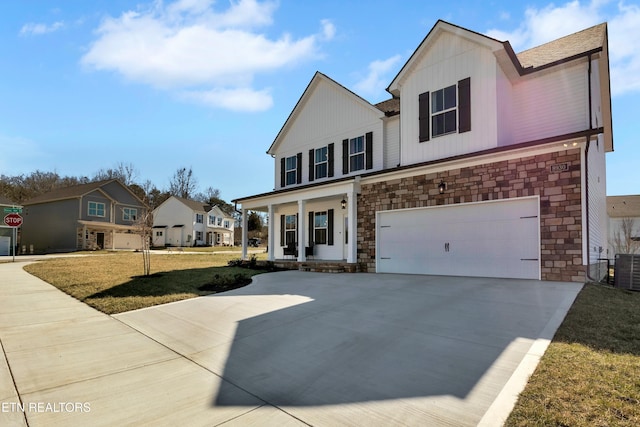 view of front of property featuring concrete driveway, board and batten siding, a front yard, a garage, and stone siding