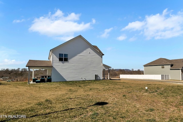 view of property exterior with fence and a yard