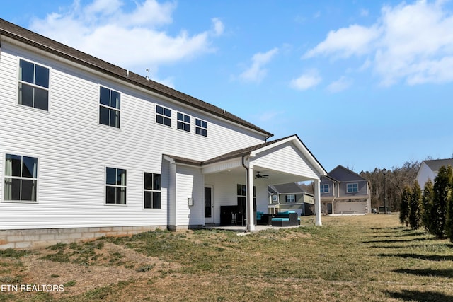 rear view of property with a patio area, a ceiling fan, and a yard