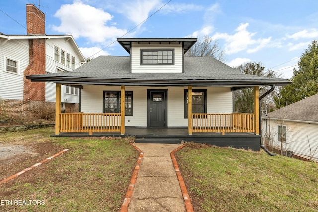 bungalow-style home featuring a porch, a front yard, and a shingled roof