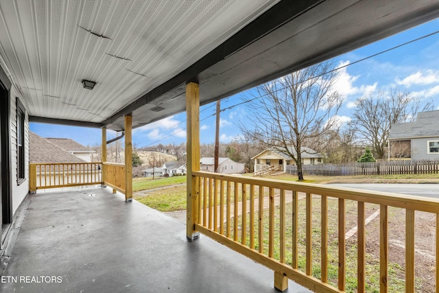 view of patio / terrace featuring a porch, fence, and a residential view