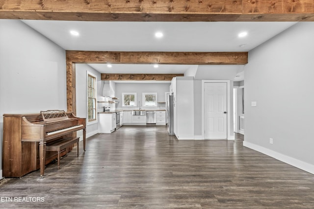 unfurnished living room with baseboards, beam ceiling, and dark wood-style flooring